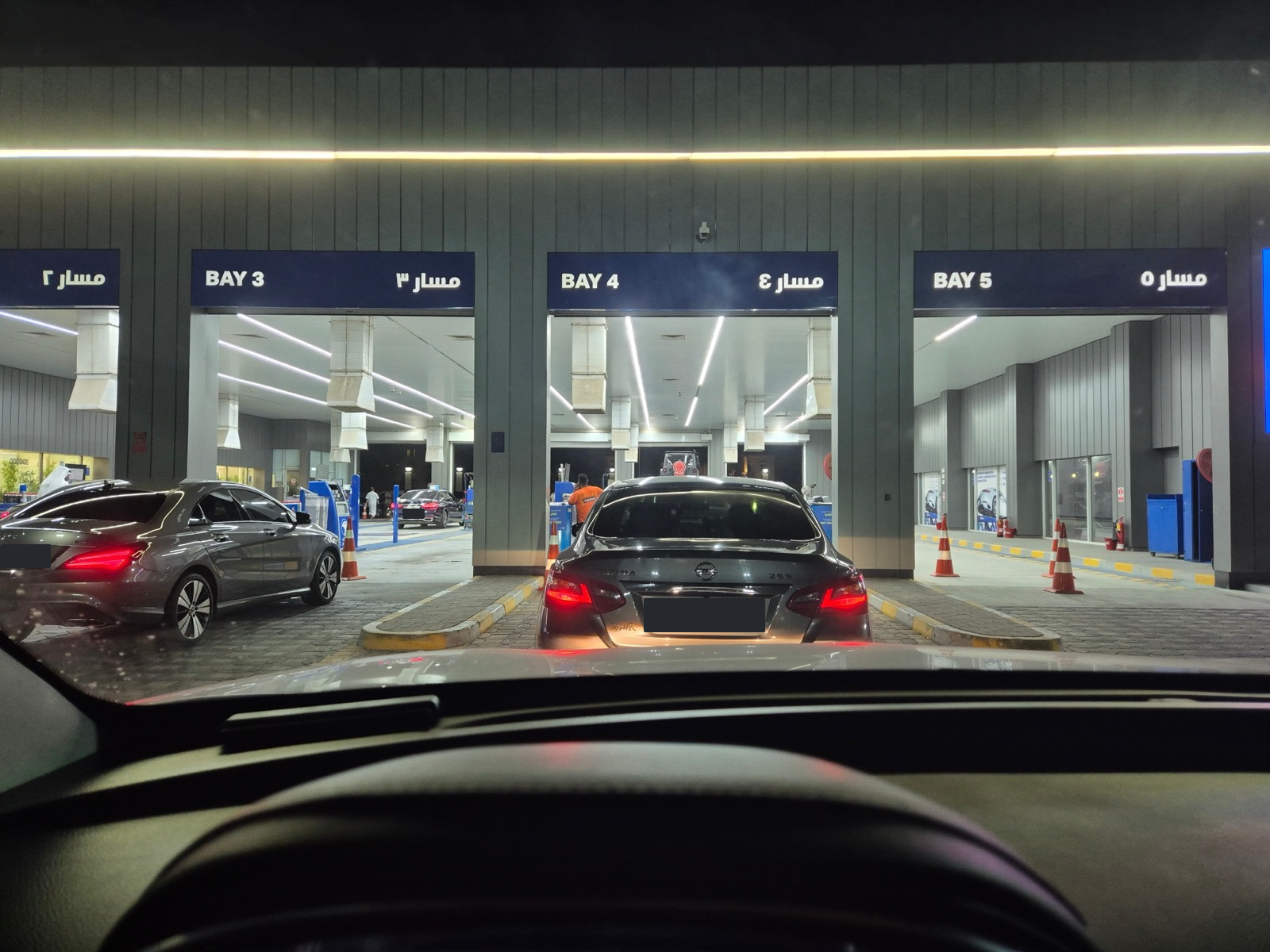 밤에 ADNOC 검사장 입구에서 순서를 기다리는 차량들